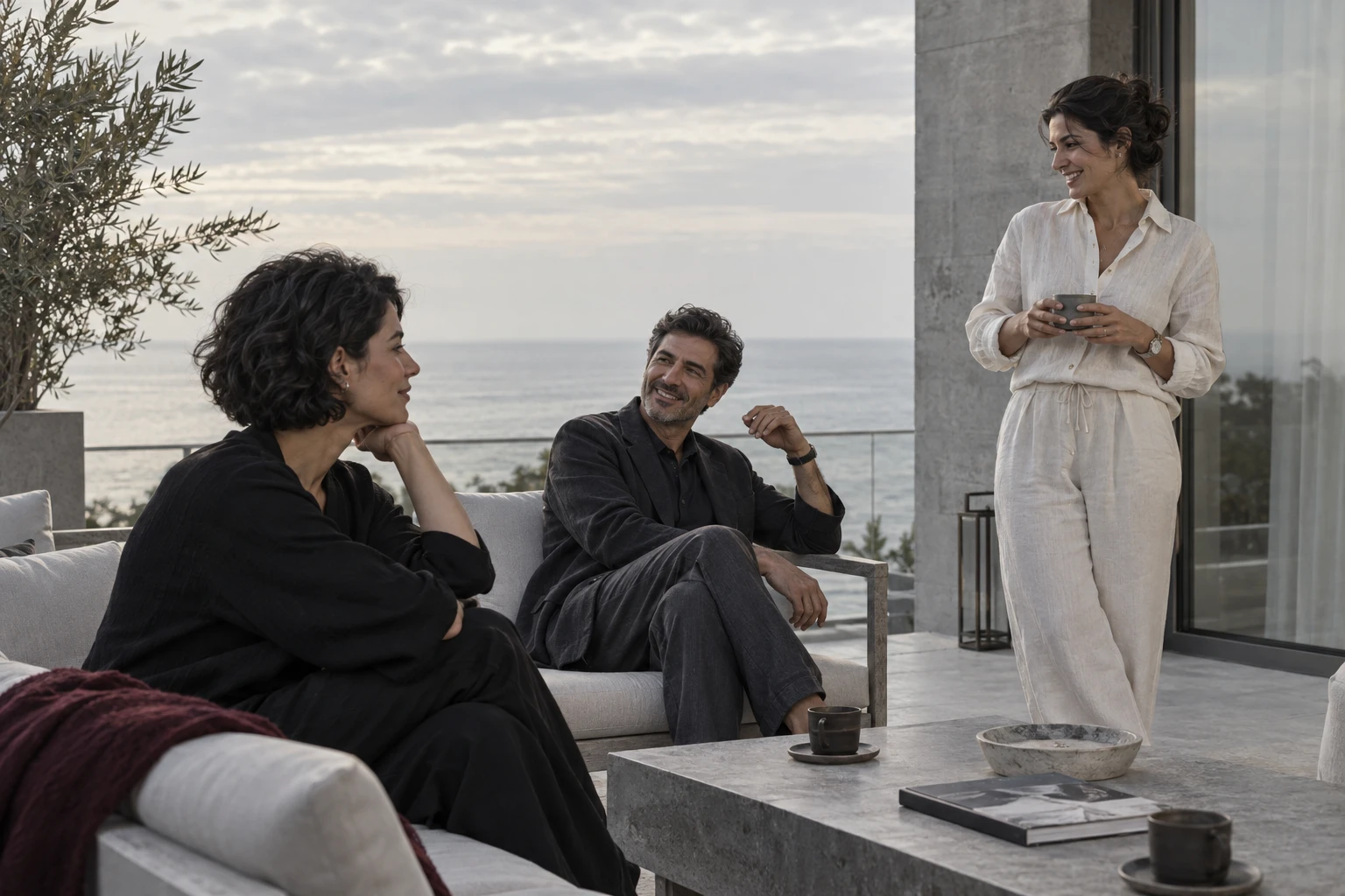 An intimate conversation between friends on a coastal terrace